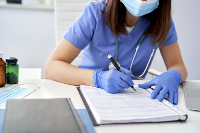 Close Up Of Female Doctor Filling Out Medical Reco Z82 Chf9 Close Up Of Female Doctor Filling Out Medical Reco Z82 Chf9